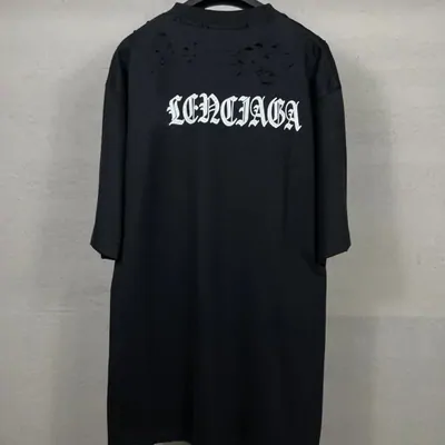 A black oversized t-shirt dress with white gothic lettering across the chest, laid flat on grey